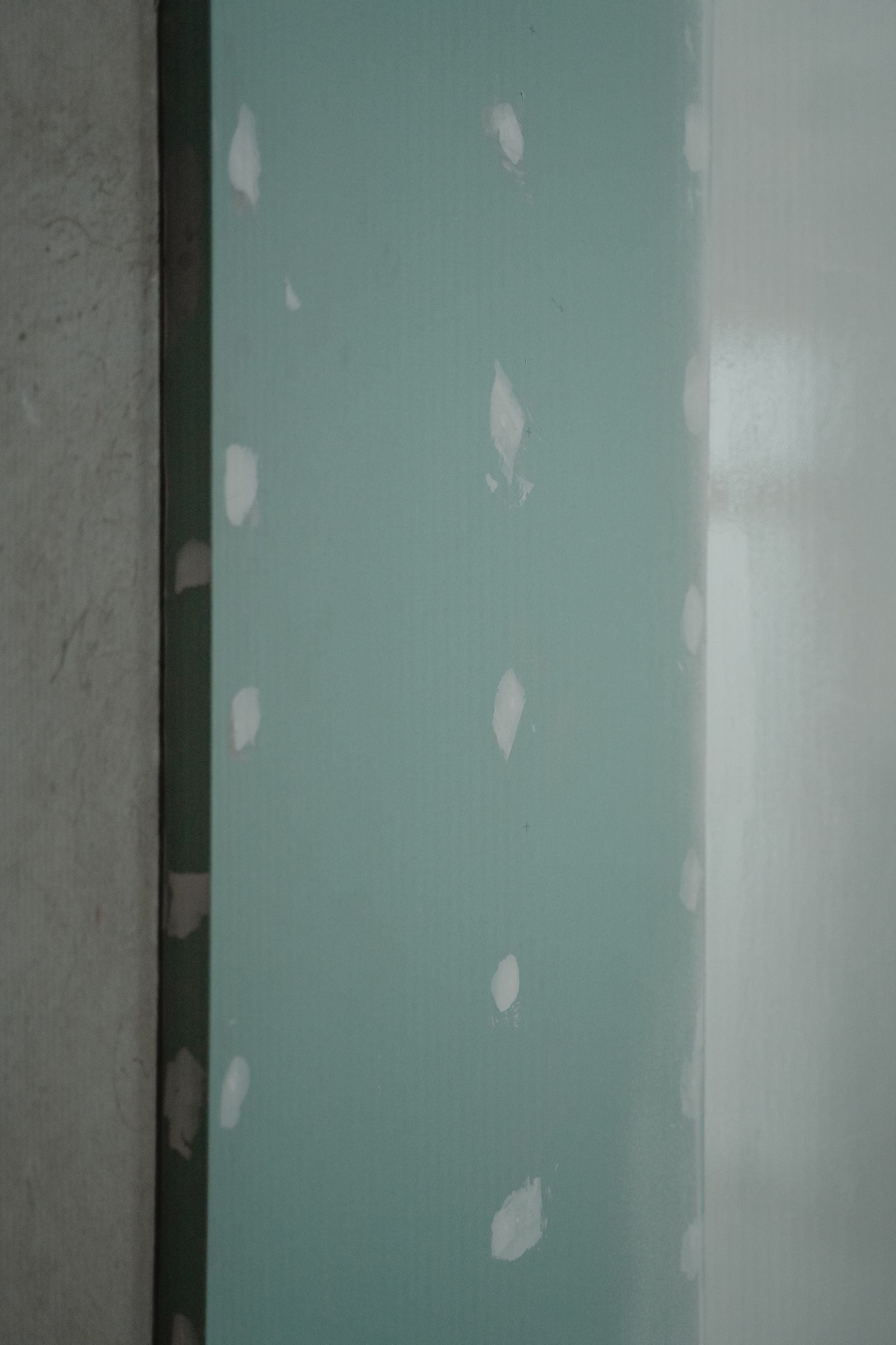 Freshly patched drywall panel during a water damage repair